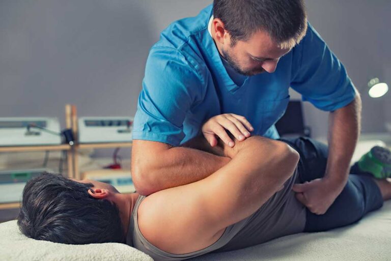 Pregnant person receiving a gentle spinal adjustment from a healthcare provider in a clinical setting.